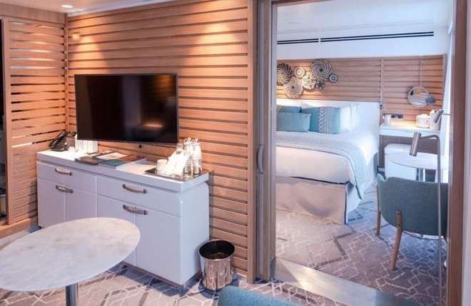 Interior suite Le Jacques Cartier dengan tempat tidur dan jendela besar